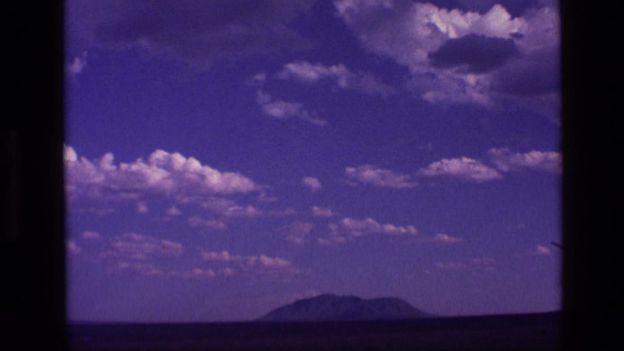 Purple-blue sky with scattered clouds above a distant low mountain horizon.