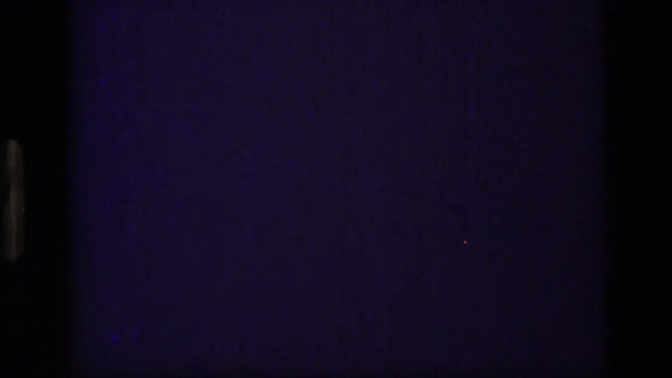 1972 Idaho 8mm frame with mostly dark obstruction and a partial view of a mountain ridge reflected in calm water.