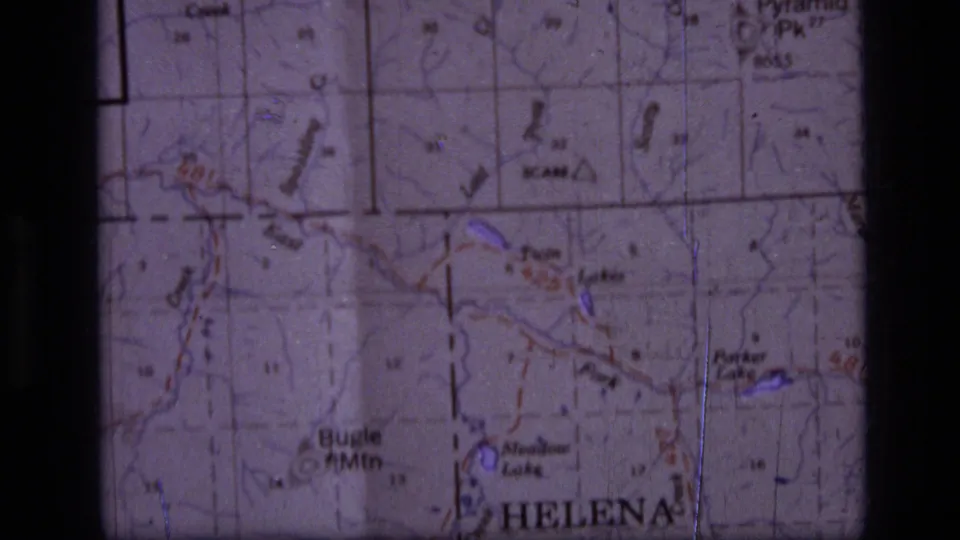 Paper Montana map viewed in close-up, with Helena and wilderness route details framed by the 8mm film gate.