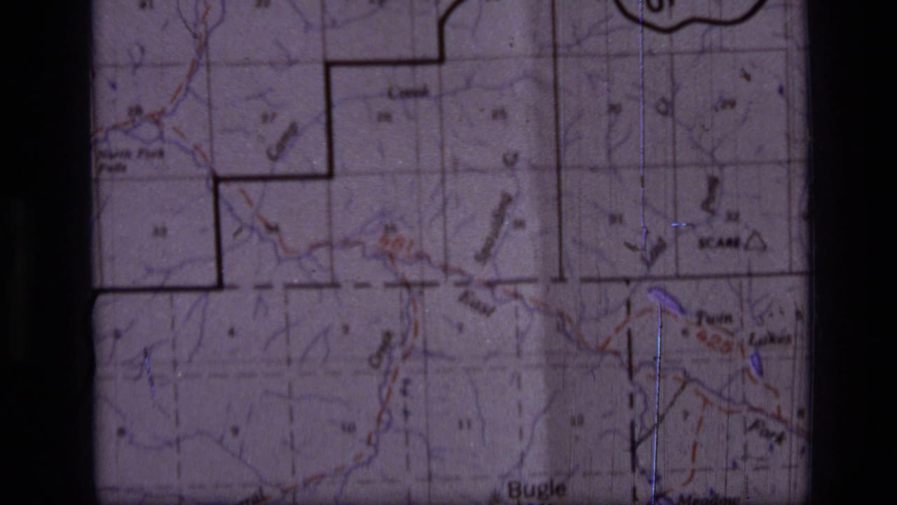 1973 8mm frame showing a Scapegoat Wilderness, Montana topographic map with grid squares, trails, labels and dark film edges.