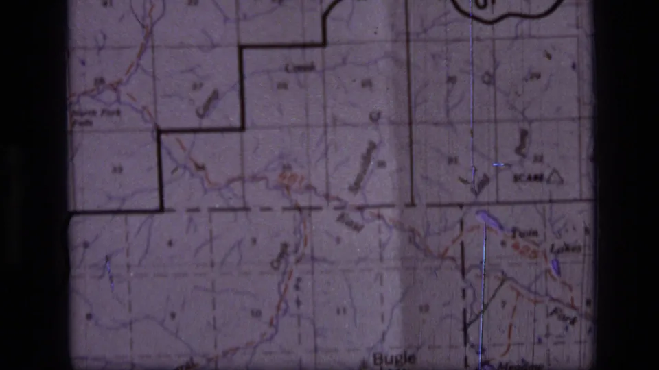 1973 8mm frame showing a Scapegoat Wilderness, Montana topographic map with grid squares, trails, labels and dark film edges.