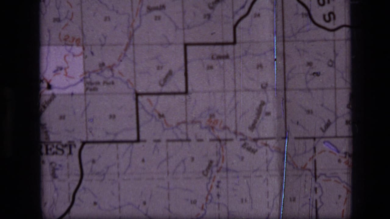 Printed map detail with a bold boundary line, grid squares and small place labels.