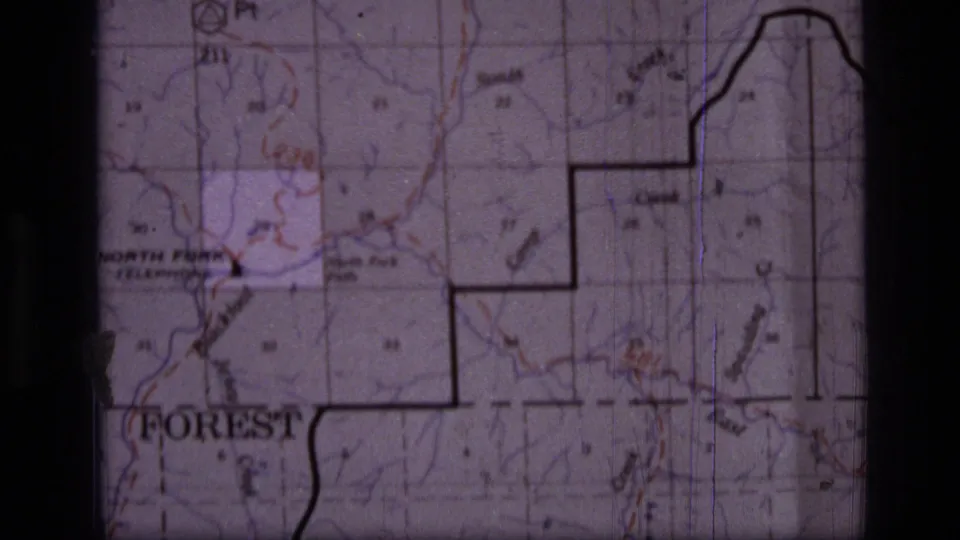 8mm frame of the Scapegoat Wilderness area map, with a partial forest label, red trail or route marks, grid lines and soft film grain.