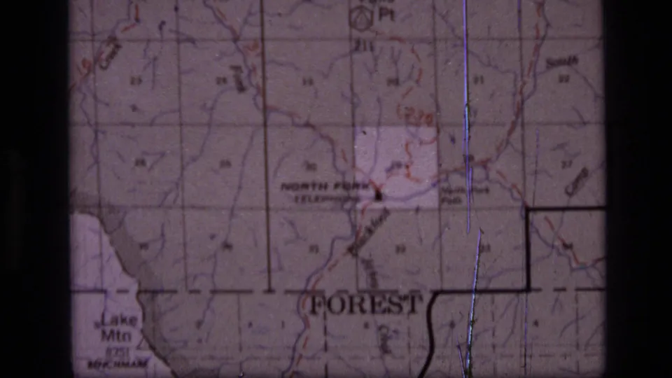 1973 8mm map frame showing Forest and Lake Mtn labels in the Scapegoat Wilderness area, with grid markings and visible film wear.