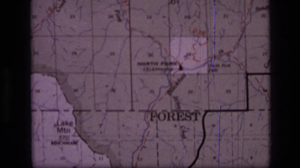 1973 8mm frame of a Montana wilderness map with North Fork, Forest, and Lake Mtn labels, plus grid and boundary markings.