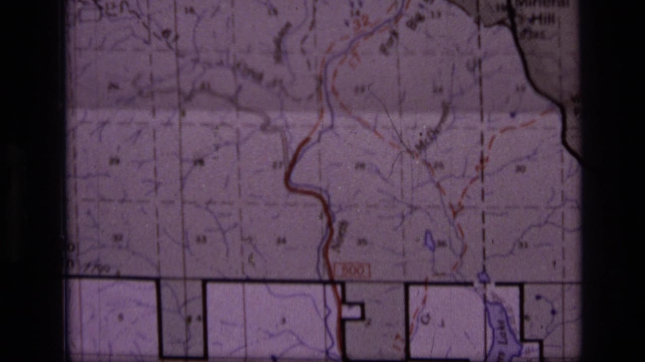 Topographic map detail with red and blue lines, black boundary outlines, grid marks, and partial place labels.