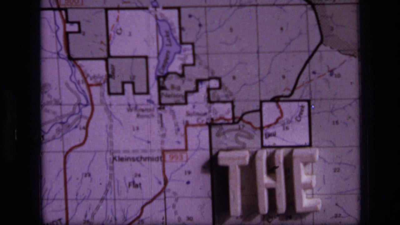 1973 8mm Montana home-movie frame showing a close topographic map view with raised plastic title letters partly reading THE END.