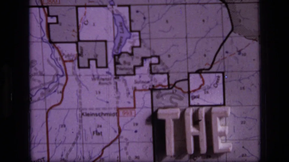 1973 8mm Montana home-movie frame showing a close topographic map view with raised plastic title letters partly reading THE END.