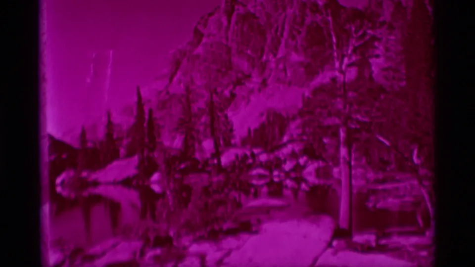 8mm frame of the lower portion of a magenta Sierra Club Bulletin wilderness cover, with trees and reflected landscape.