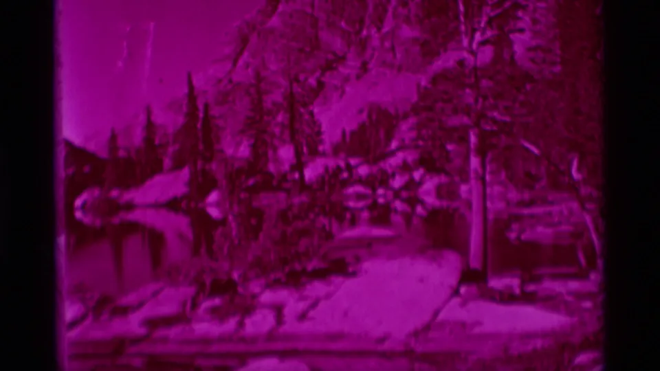 End frame of the 1975 8mm clip showing the magenta wilderness publication cover with trees, water, and page detail.