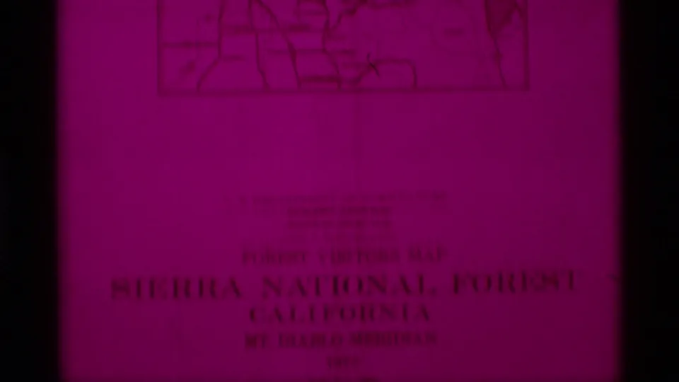Magenta 8mm frame of a Sierra National Forest visitor map, with inset map lines and title text visible.