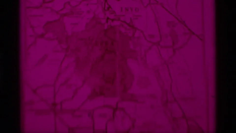 A soft 8mm frame shows the visitors map in heavy magenta color shift, with roads or boundaries and faint California region labels.