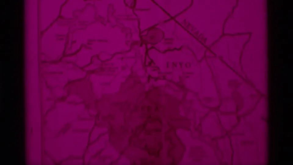 Close map detail with red color cast and visible Inyo labeling, used as a geographic cue in the 1975 California wilderness clip.