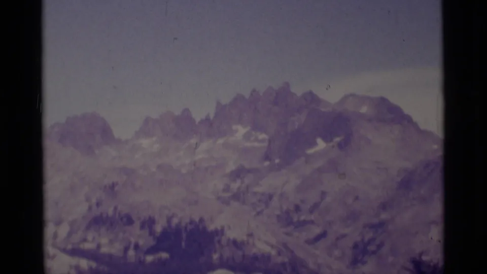 End of a 1975 8mm pan across the Minaret Wilderness area, showing softened peaks, snow remnants, and a subdued gray sky.