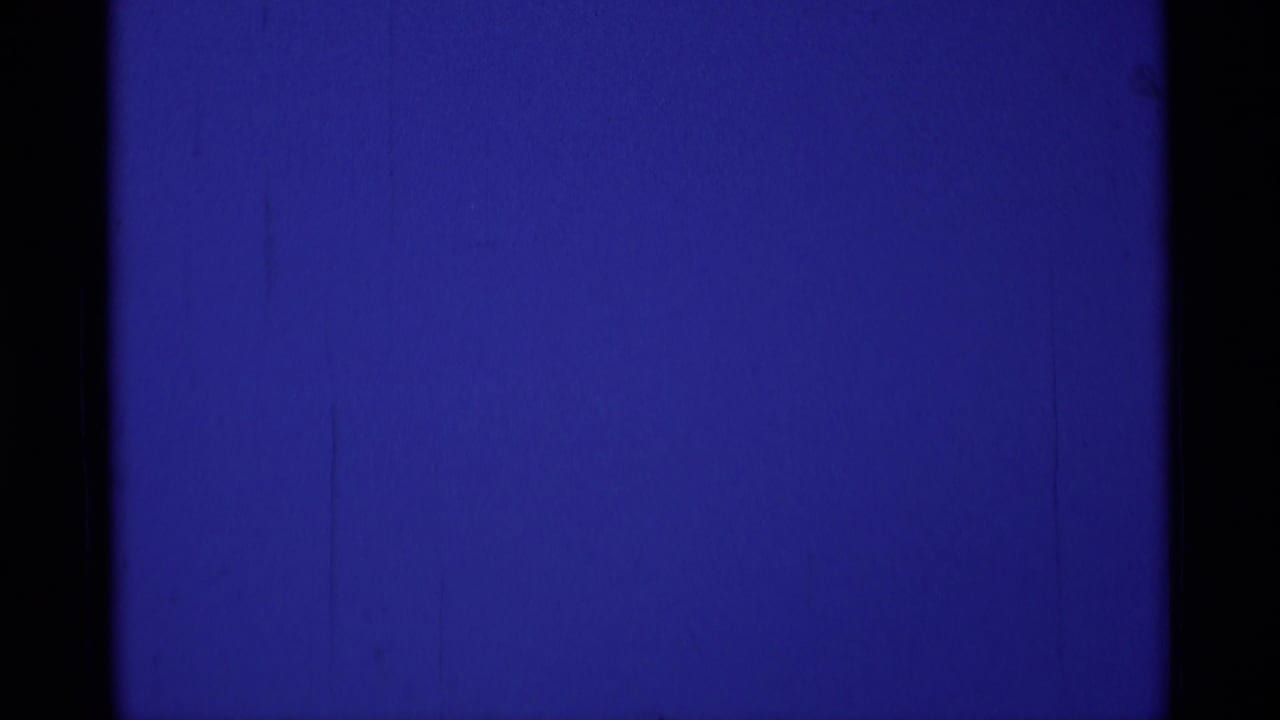 Deep blue sky with visible grain and dark vertical film borders.