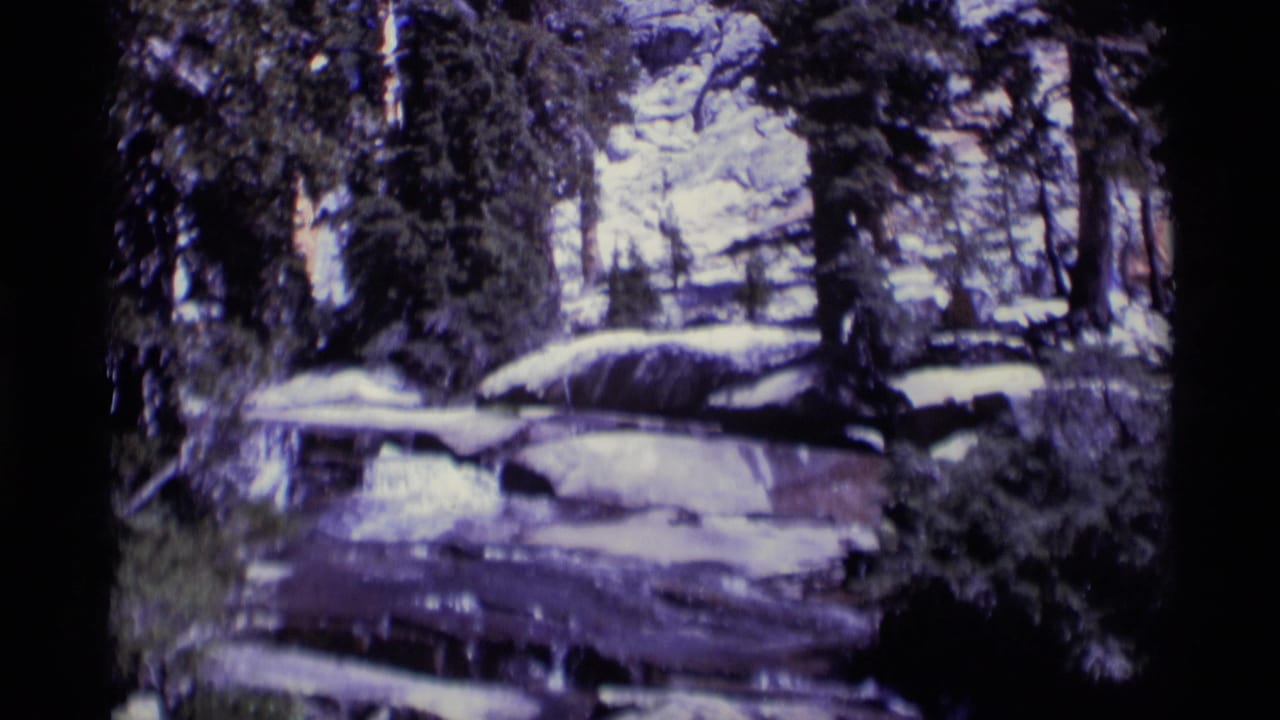 1975 8mm footage from Minaret Wilderness showing water flowing over layered rocks among evergreen trees.