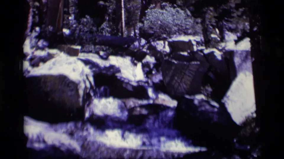 A wider 8mm frame shows Minaret Wilderness creek water threading through boulders beneath shaded trees and brush.