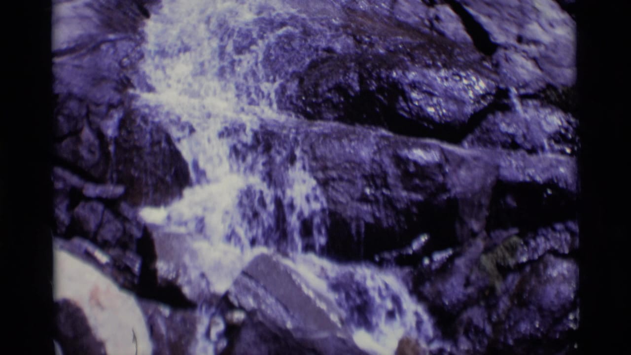 1975 8mm home-movie frame from Minaret Wilderness showing white water spilling across dark, wet rocks.