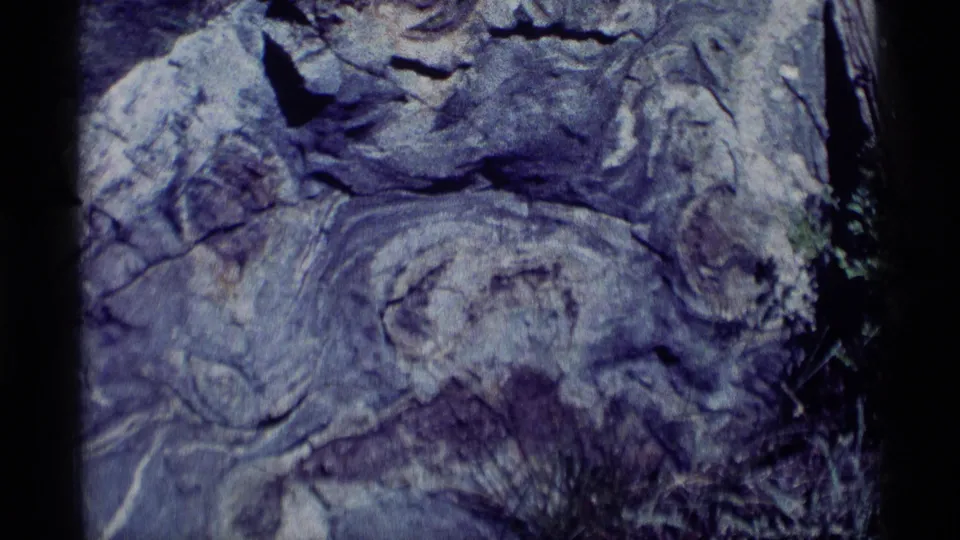 1975 Minaret Wilderness frame focused on textured rock surfaces, with the chipmunk no longer clearly visible.