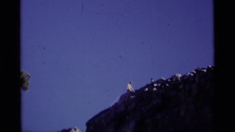 A small hiker appears on the crest of a rugged Minaret Wilderness ridge in this 1975 8mm home-movie frame.