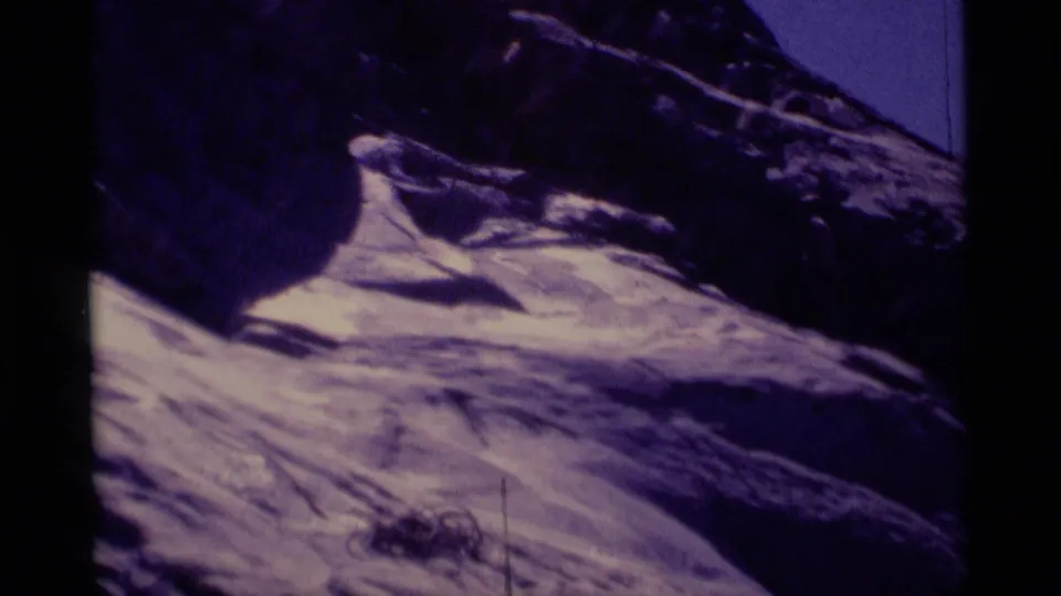 1975 8mm view of Minaret Wilderness terrain, showing dark rock above a pale sloping mountainside with heavy purple color shift.