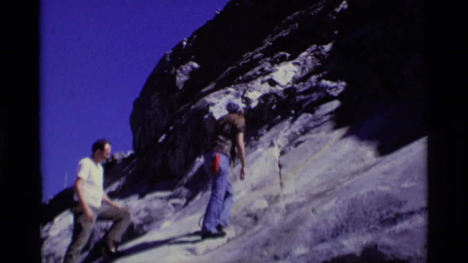 Climbers on a Minaret Wilderness granite face with a rope visible against the rock in 1975 8mm home-movie footage.