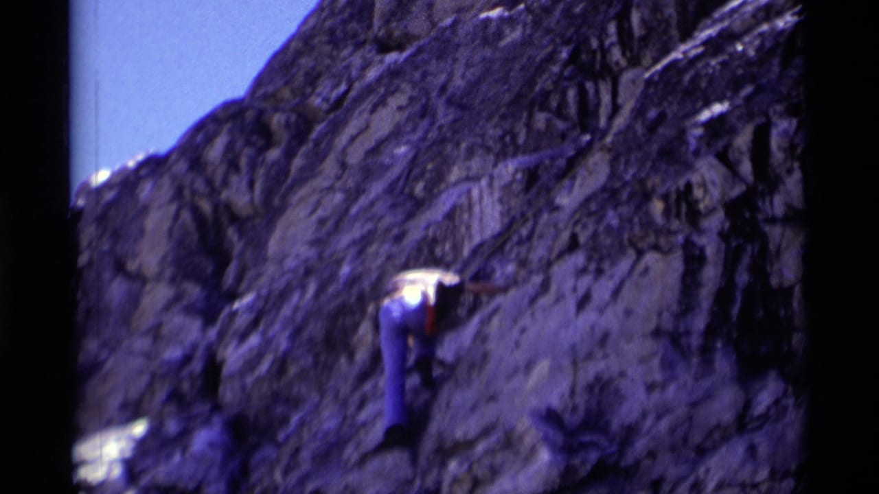 1975 California wilderness frame showing the climber pressed against a steep, textured rock surface while ascending.