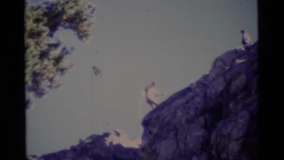 Minaret Wilderness 8mm frame showing a climber using a rope on the cliff with another person above.