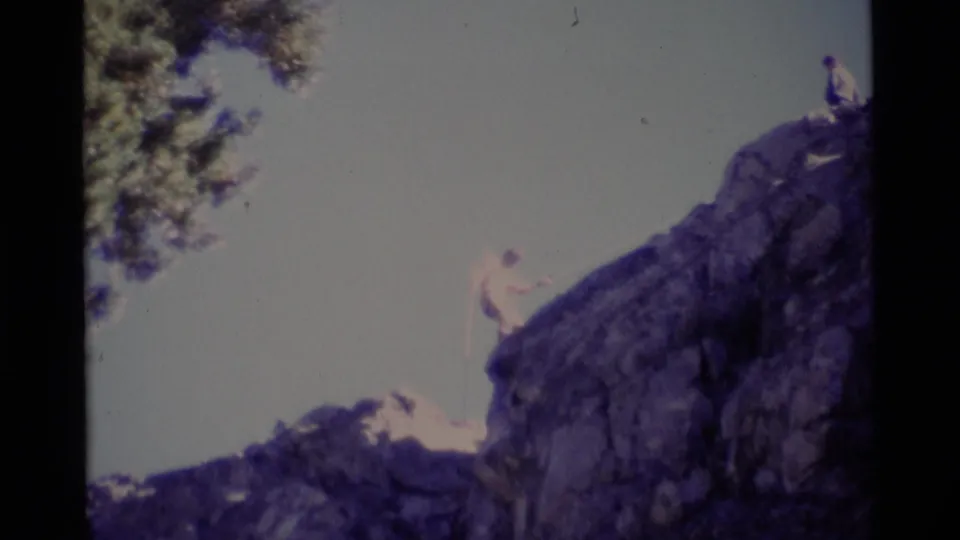 1975 8mm home-movie frame of a climber on a Minaret Wilderness rock face with a second figure above.