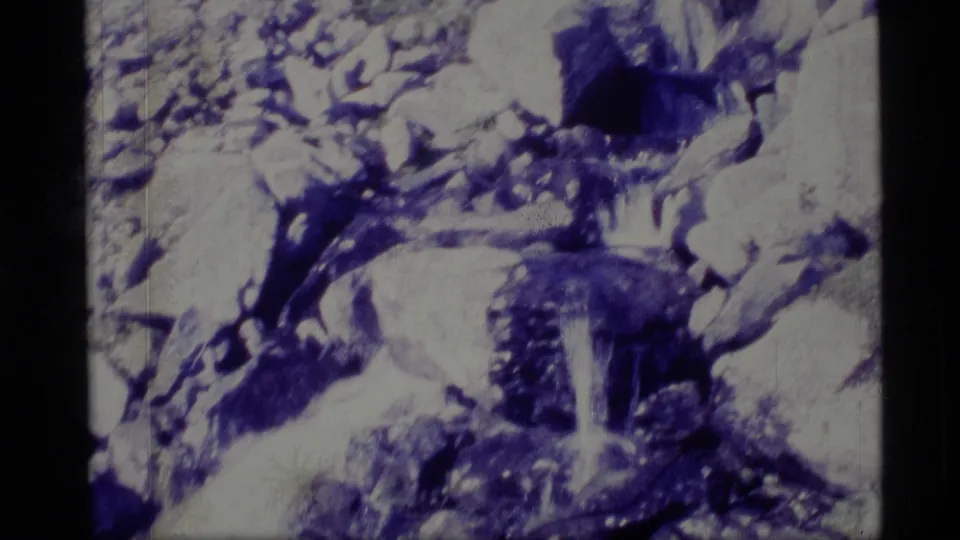 1977 Alaska 8mm view of water moving through rocks and snow-dusted terrain, with soft focus and visible film grain.