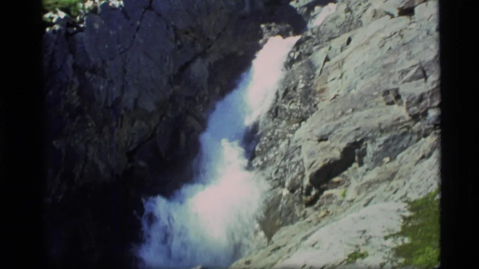 1977 Alaska 8mm close view of foaming river water running between dark and sunlit canyon rocks.