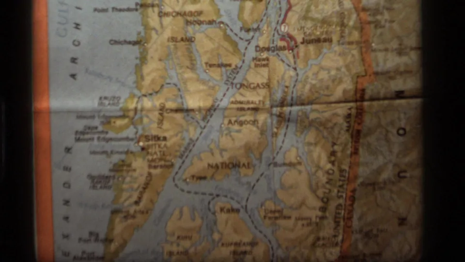 1977 8mm frame centered on an Alaska map with Tongass-region labels, islands, water channels, and border markings.