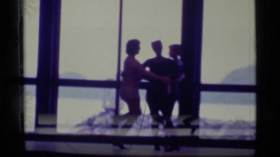 Three dancers appear in silhouette before large windows in the supplied 1977 Alaska dance-practice footage.