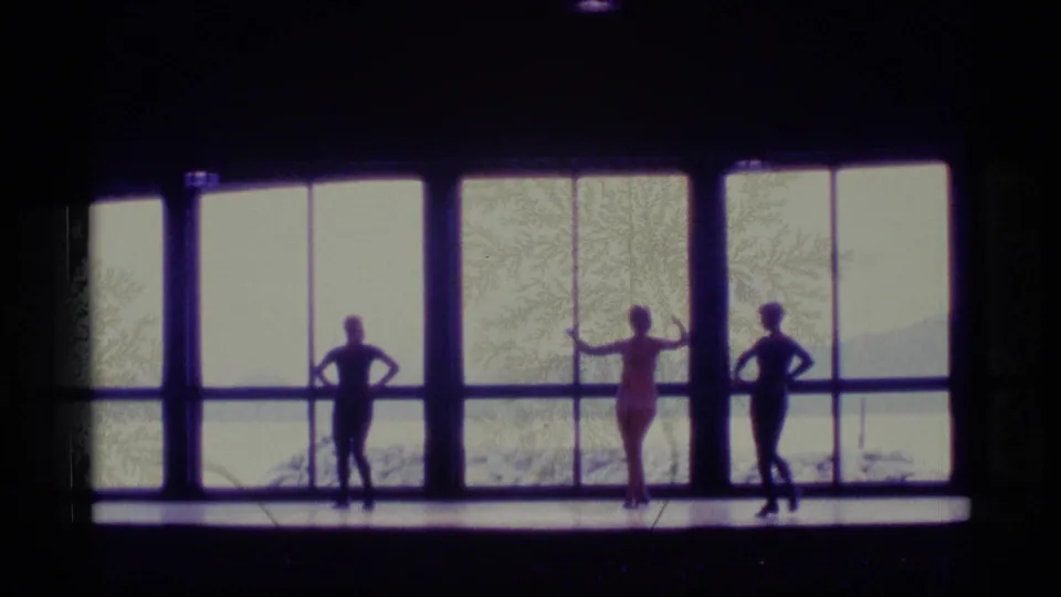 The trio holds a spaced formation against the bright window wall, creating strong silhouettes in the 1977 Alaska footage.