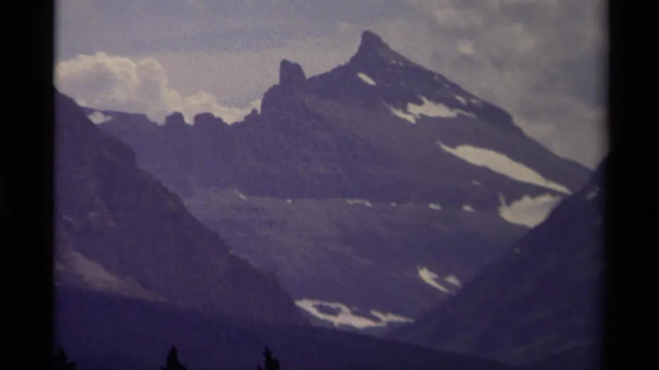 1979 Canada 8mm view of a distant mountain range with snow-streaked slopes and muted overcast light.