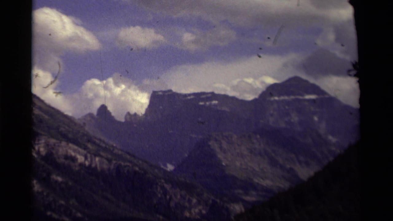 Canadian mountain landscape from 1979 home-movie footage, with distant peaks, heavy clouds, and visible film wear.
