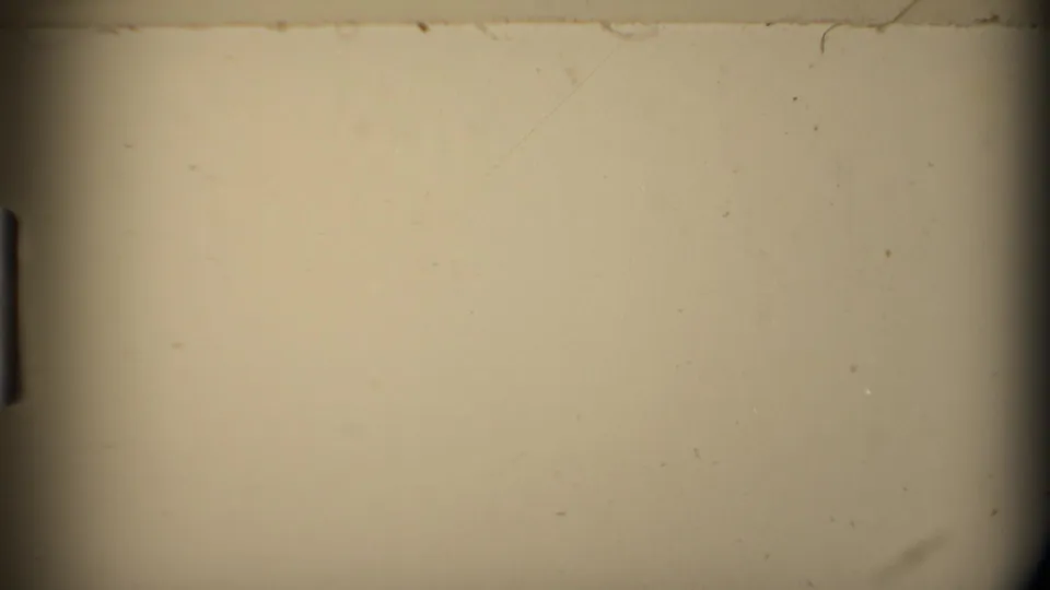 End frame from the 8mm scan showing a mostly blank beige film area with dust, scratches, and dark edge falloff.