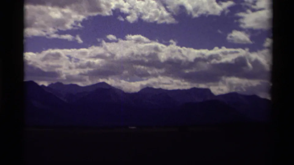 End frame emphasizing a dark mountain ridge and luminous cloud formations in a Canadian 8mm travel landscape.
