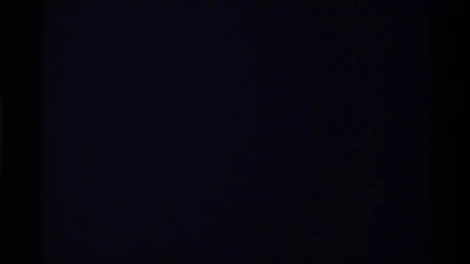 Dark exposed section of the 8mm clip with no clear subject visible beyond faint color and film edge darkness.