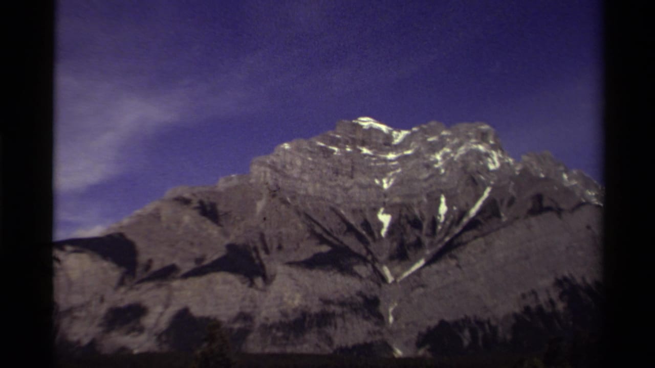 1979 Canadian 8mm frame showing a distant snow-capped mountain range under a saturated purple sky.