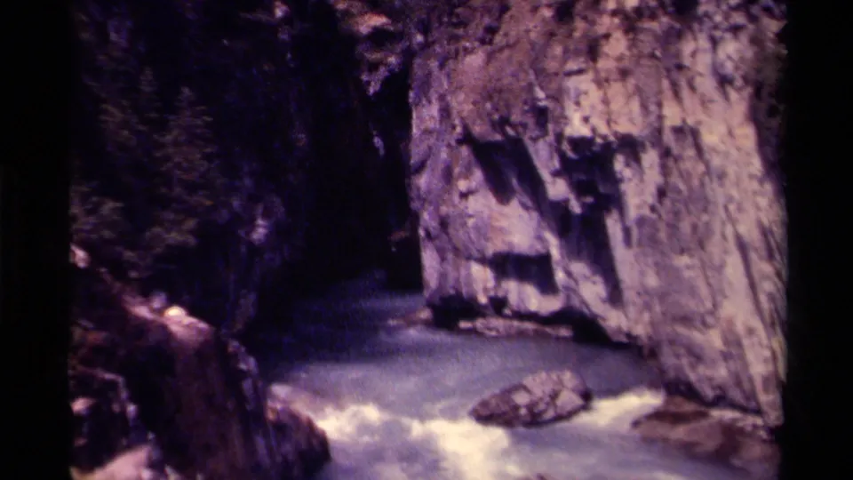 1979 Canada 8mm closing frame with swift pale water, canyon rock, and a dark shaded passage.