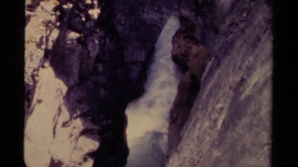 1979 Canadian 8mm frame showing rushing water between dark, close-set canyon rocks.