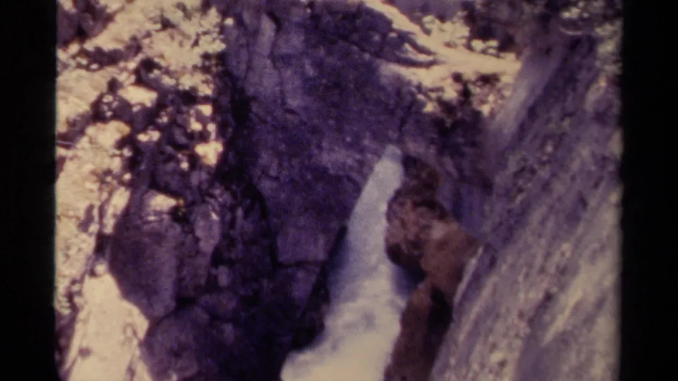 1979 Canada 8mm frame showing foamy water in a rocky canyon, with handheld framing and aged color shift.