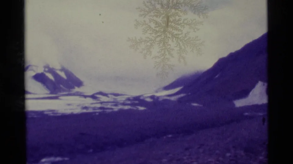 1977 Alaska 8mm view of a snowy ridgeline and large purple-shifted mountain slope with soft archival texture.