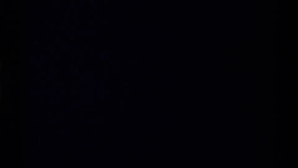 Underexposed 8mm frame with most detail lost in shadow, likely during handheld movement in the canyon.