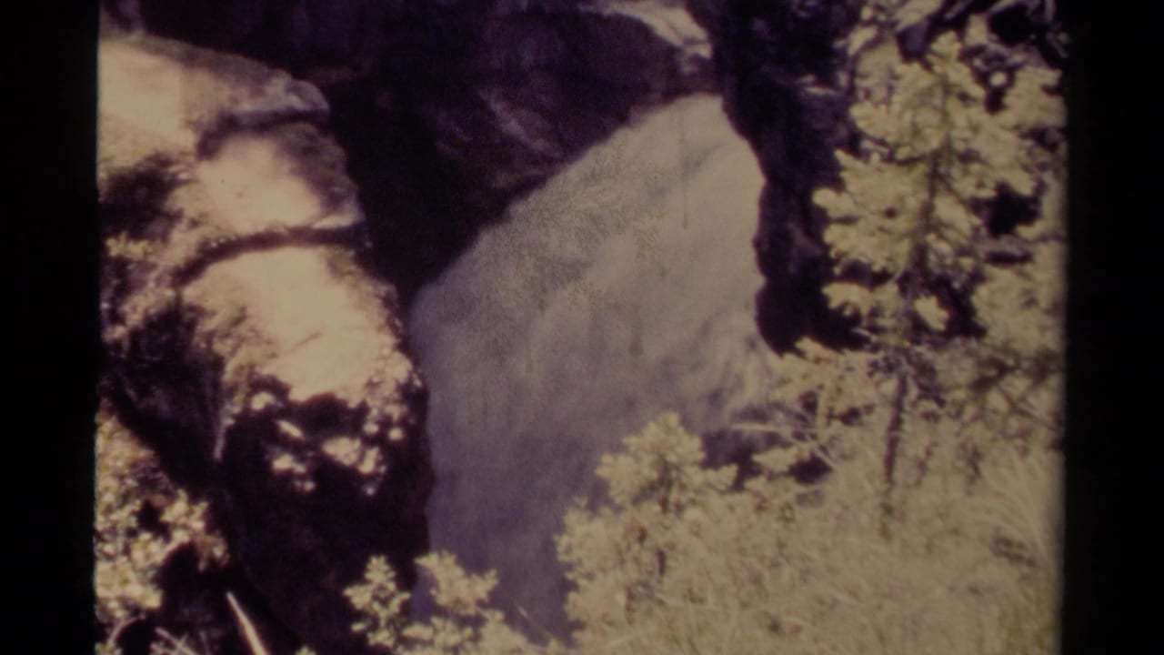 1979 Canadian 8mm view of a secluded waterfall beside rugged rock, with shrubs and washed color in the frame.