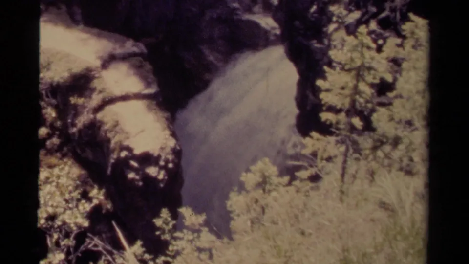1979 Canadian 8mm frame showing a rushing waterfall tucked against canyon rock and surrounding vegetation.