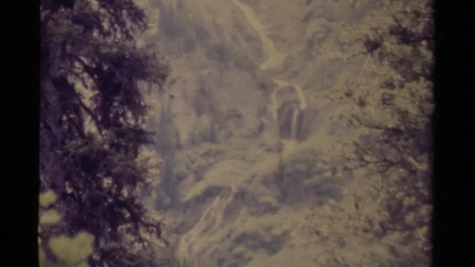 1979 Canadian 8mm frame showing a misty waterfall or cascade partly obscured by trees and soft exposure.