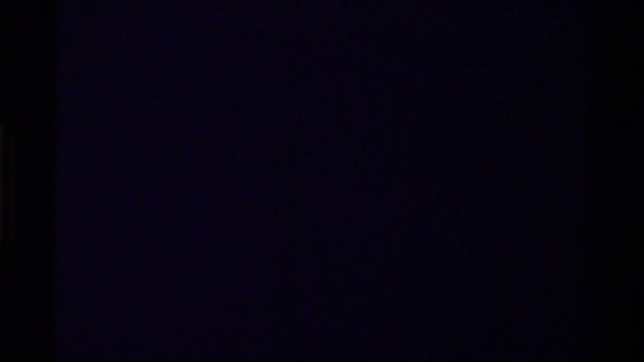 Mostly dark underexposed frame with faint purple-black film texture.