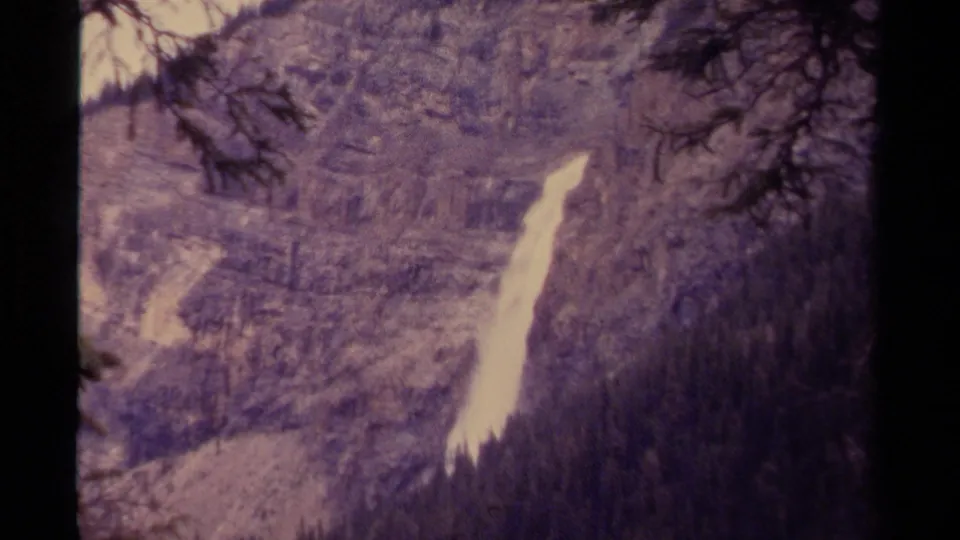 1979 Canada home-movie frame showing the waterfall more closely against a rocky, tree-covered slope.